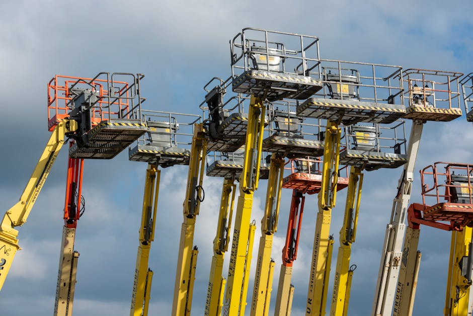 Operator sprawdzający stabilność podnośnika na placu budowy