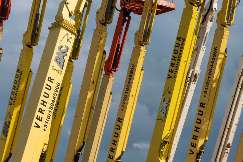 Operator sterujący podestem ruchomym w trakcie prac instalacyjnych na nowoczesnej hali magazynowej