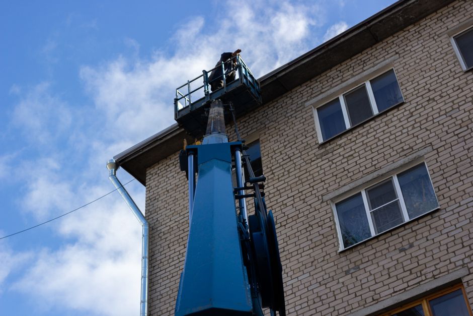 Podnośnik koszowy pracujący na budowie w otoczeniu nowoczesnych konstrukcji