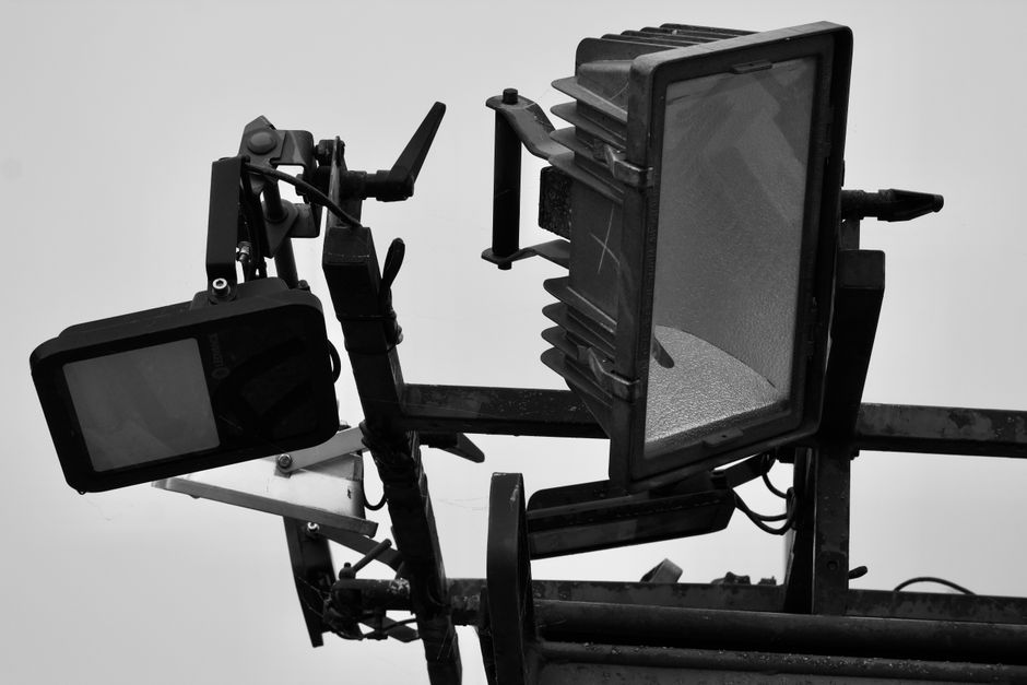 Ekipa techniczna używająca podnośnika nożycowego do montażu lamp pod wysokim stropem hali